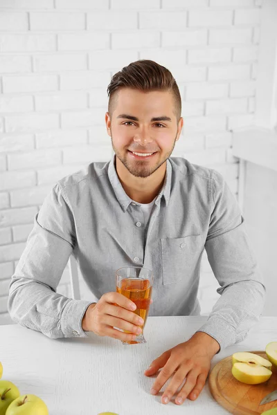 Homme montrant un verre de jus de pomme — Photo