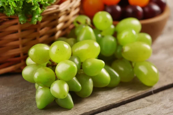 Heap of fresh fruits and vegetables in basket on wooden table close up — Stock Photo, Image