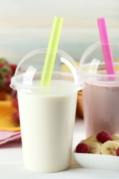 Plastikbecher Milchshake auf hellem Holzhintergrund — Stockfoto