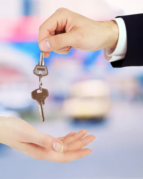 Keys in hand on blurred  store — Stock Photo, Image