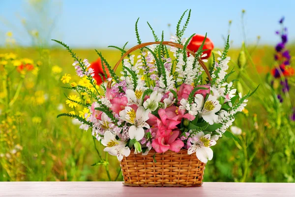Beautiful wildflowers in wicker basket — Stock Photo, Image