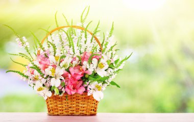 Alan arka plan üzerinde hasır sepet içinde güzel kır çiçekleri