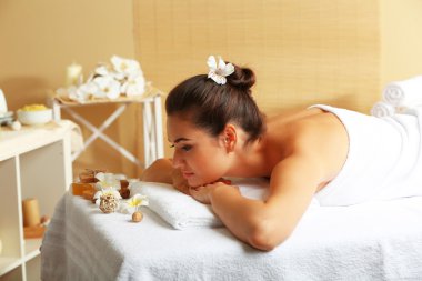 Masaj masasındaki genç kadın.