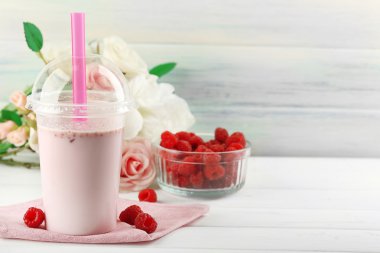 Milkshake hafif ahşap arka plan üzerinde plastik bardak