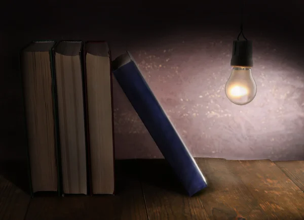 Lightbulb and books on shelf — Stock Photo, Image