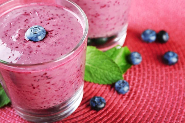 Glazen blueberry smoothie op roze mat, close-up — Stockfoto