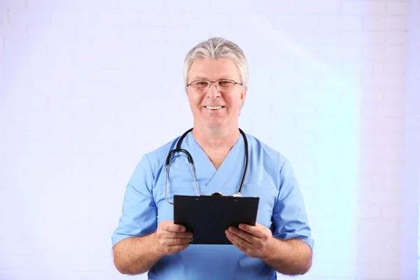 Γιατρός με πρόχειρο σε γαλάζιο φόντο — Φωτογραφία Αρχείου
