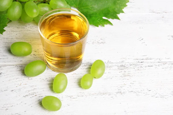 Verre de jus de raisin sur table en bois, gros plan — Photo