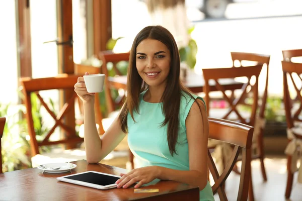 Belle jeune femme avec tablette numérique dans le café — Photo