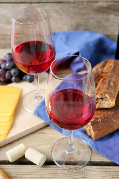 Still life of wine, grape, cheese and bread on rustic wooden background — Stock Photo, Image