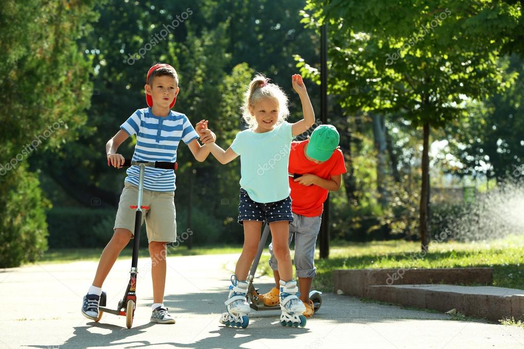 Children riding on scooters and roller skates