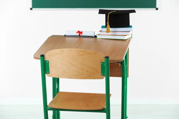 School desk with master hat — Stock Photo, Image