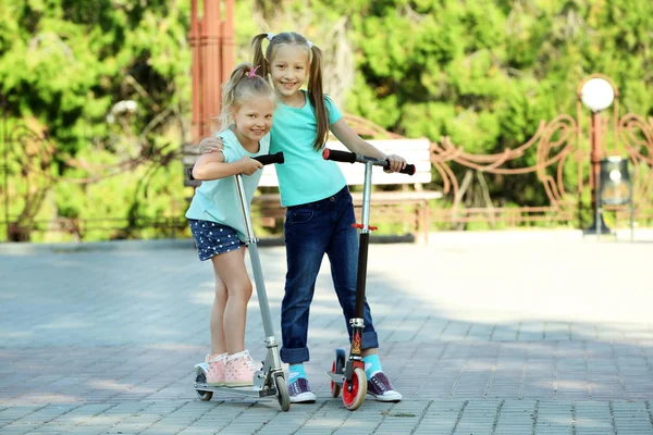 Kleine Mädchen fahren auf Rollern — Stockfoto