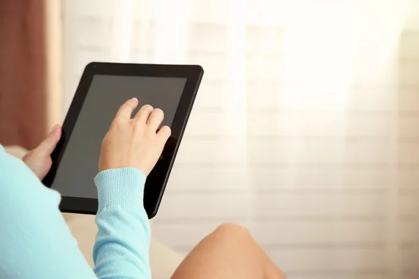 Weibliche Hand hält PC-Tablet auf Home-Innenhintergrund — Stockfoto