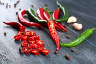 Hot peppers with spices on wooden table close up clipart