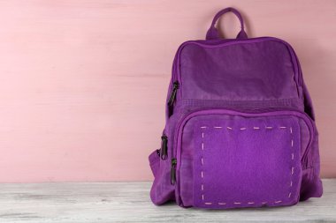 Ahşap arka plan üzerinde okul sırt çantası