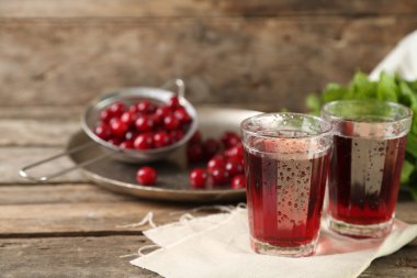 İki kadeh tabloda, ahşap arka plan üzerinde vişne suyu ile