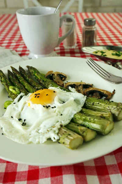 Asparagi arrosto con uovo in camicia su fondo tavola — Foto Stock