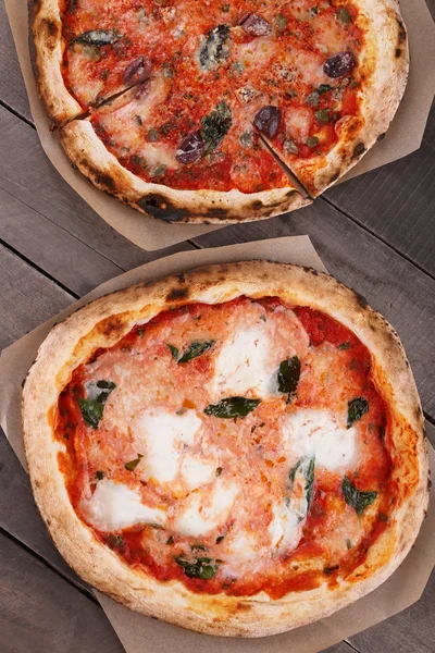 Deliciosas pizzas na mesa de madeira, close-up — Fotografia de Stock