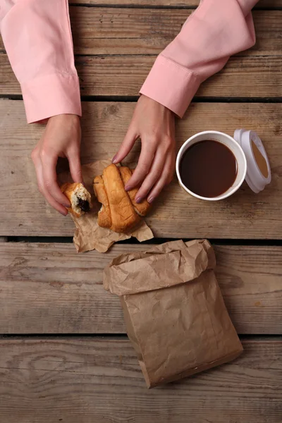 Γυναικεία χέρια που κρατούν το φλιτζάνι του καφέ και τα cookies στο τραπέζι ξύλινο κοντινό πλάνο — Φωτογραφία Αρχείου