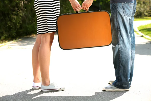 Young couple holding vintage suitcase — Stock Photo, Image