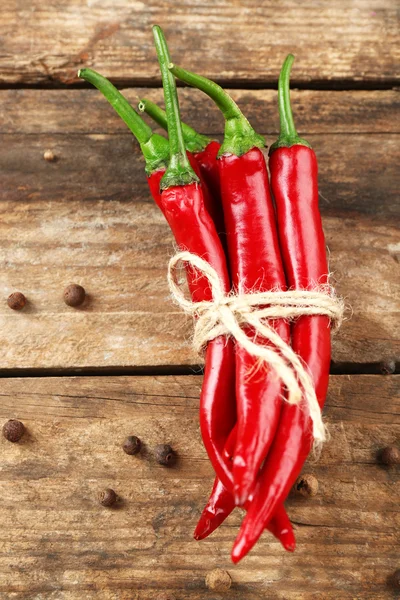 Red hot peppers with spices on wooden table close up — Stock Photo, Image