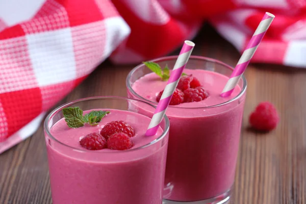 Glazen raspberry milkshake met bessen op houten tafel close-up — Stockfoto