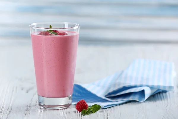 Glas Himbeermilchshake mit Beeren auf Holzgrund — Stockfoto