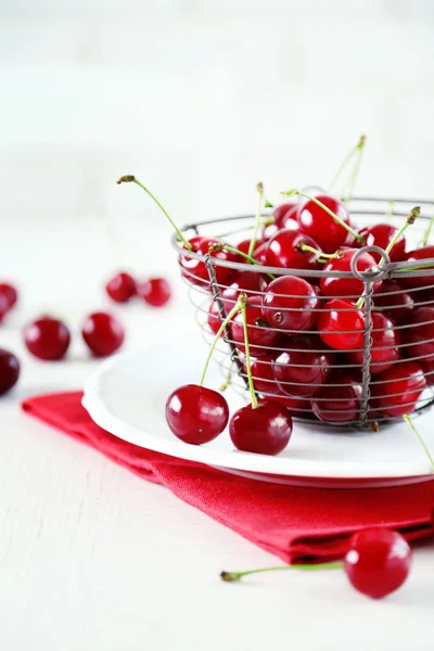 Cherries in basket on table, on light background — Stock Photo, Image