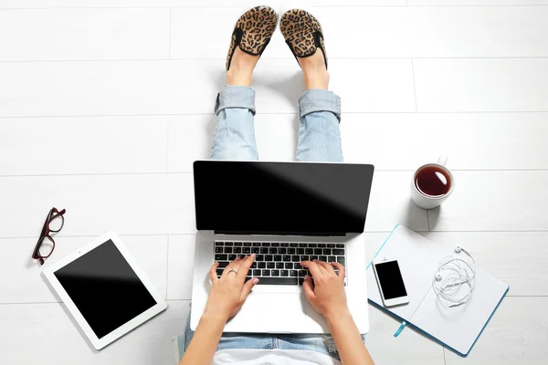 Visão superior da jovem mulher sentada no chão com laptop — Fotografia de Stock