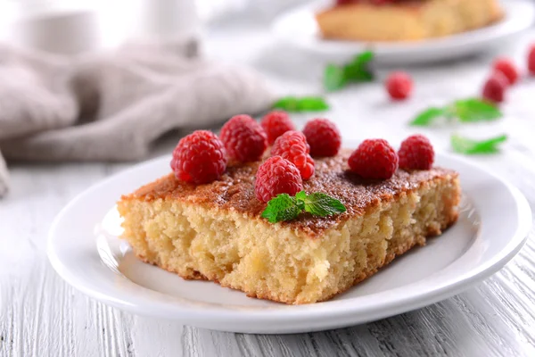 Tarte fraîche à la framboise en assiette blanche sur table en bois, gros plan — Photo