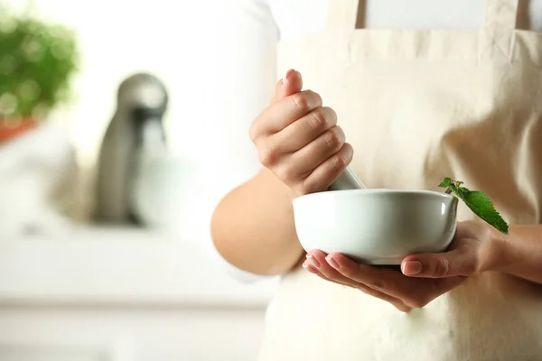 Mains féminines avec mortier aux herbes — Photo