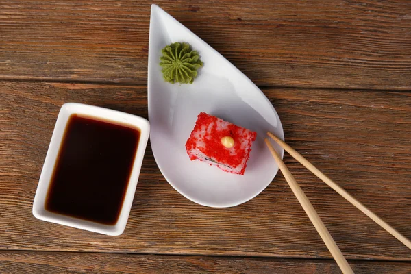 Roll with sauce and sticks on wooden table close up — Stock Photo, Image