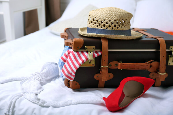 Чемодан с одеждой на кровати
