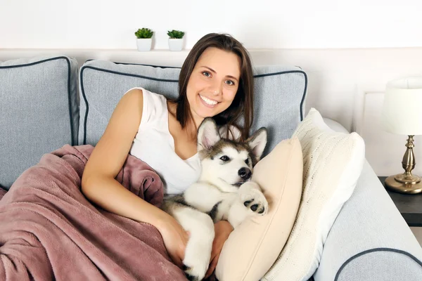 Young woman lying with malamute dog — Stock Photo, Image