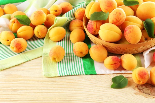 在柳条碗上的木桌上的餐巾，特写成熟杏子 — 图库照片