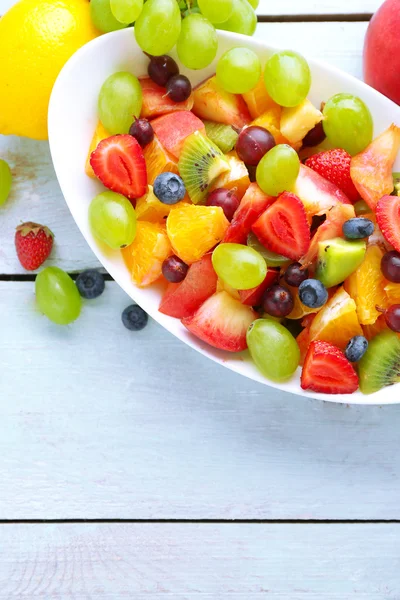 Ahşap masa üzerinde taze meyve salatası — Stok fotoğraf