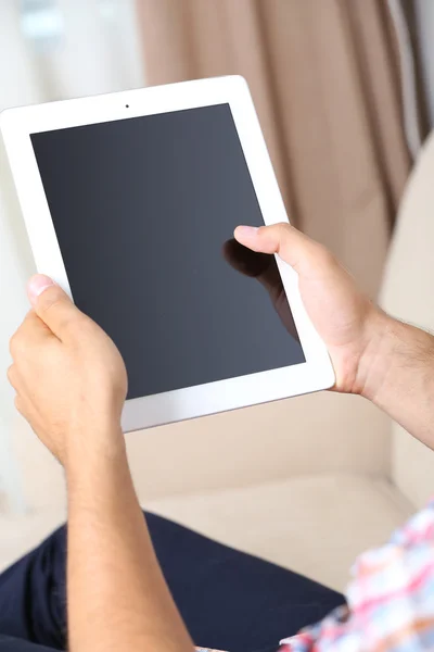 Männliche Hand hält PC-Tablet auf Home-Innenhintergrund — Stockfoto
