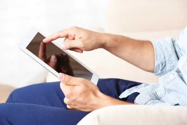 Mão masculina segurando tablet PC em casa fundo interior — Fotografia de Stock