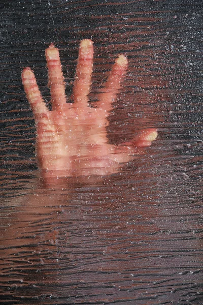 Мужская рука за стеклом — стоковое фото