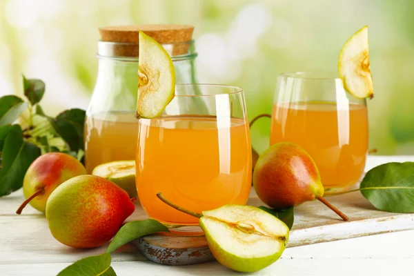 Glass of juice with fresh pears on wooden table on blurred background — Stock Photo, Image