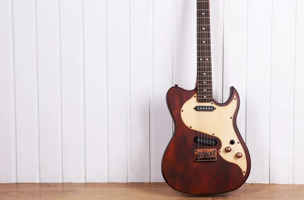 Electric guitar on white wooden wall background — Stock Photo, Image