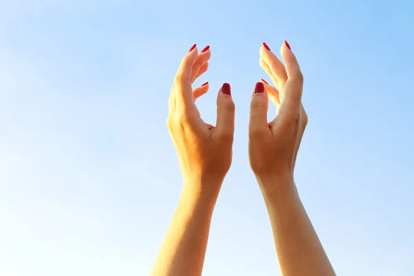 Mãos femininas sobre fundo céu azul — Fotografia de Stock