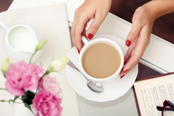 Female hand holding cup of coffee on table close up — Stock Photo, Image