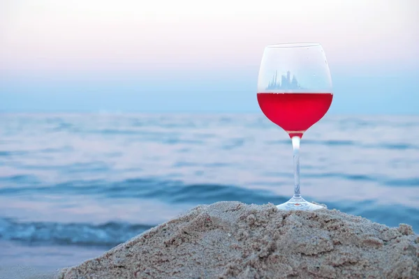 Romántica copa de vino sentada en la playa al atardecer — Foto de Stock