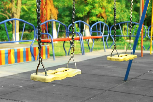 Порожнє сидіння гойдалок на дитячому майданчику в парку — стокове фото