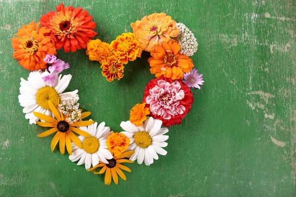 Färgglada blommor i form av hjärta träbord, närbild — Stockfoto
