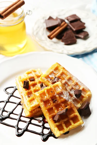 Sweet homemade waffles with chocolate sauce on plate, on light background — Stock Photo, Image