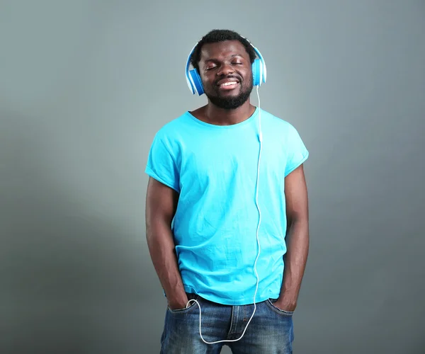 African American man with headphones on grey background — Stock Photo, Image