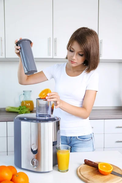 Wanita cantik muda menggunakan juicer — Stok Foto